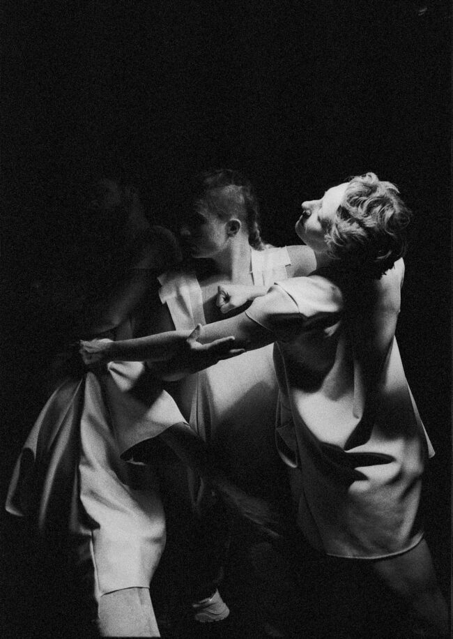 Jon Ander Urresti - Antigone. Plano medio. Imagen en blanco y negro. Tres figuras forcejean, en gesto parecido a una danza.